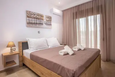 a bedroom with a large bed with towels on it at M&E APARTMENTS in Haraki