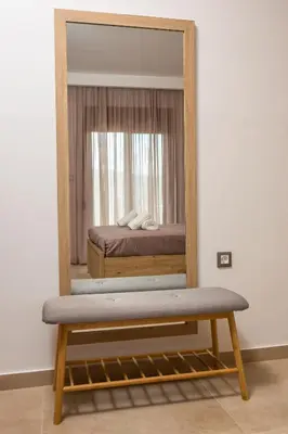 a mirror in a room with a bed and a bench at M&E APARTMENTS in Haraki