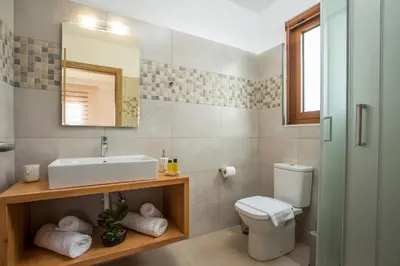 a bathroom with a sink and a toilet and a mirror at M&E APARTMENTS in Haraki