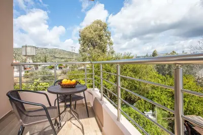 a balcony with a table and chairs and a view at M&E APARTMENTS in Haraki