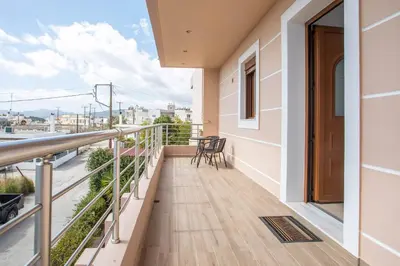 a balcony with a table and chairs on it at M&E APARTMENTS in Haraki