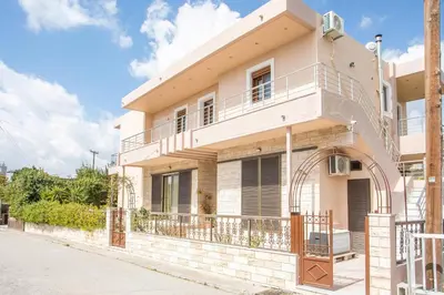 a white house with a balcony on a street at M&E APARTMENTS in Haraki
