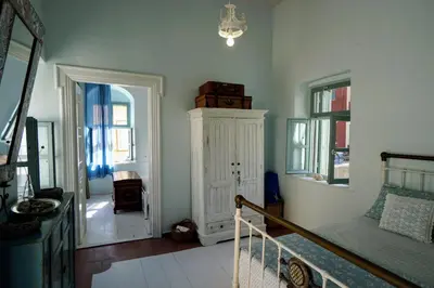 a living room with a bed and a cabinet at Say Yes Symi House in Symi