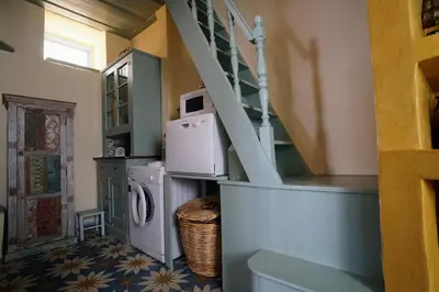 a laundry room with a washing machine and a staircase at Say Yes Symi House in Symi