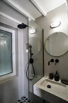 a bathroom with a shower and a sink and a mirror at Say Yes Symi House in Symi