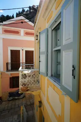 an open window on a building with a balcony at Say Yes Symi House in Symi