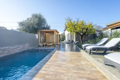 a swimming pool with lounge chairs next to a house at City Art Villa in Asgourou
