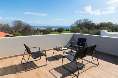 a patio with chairs and a table on a roof at City Art Villa in Asgourou