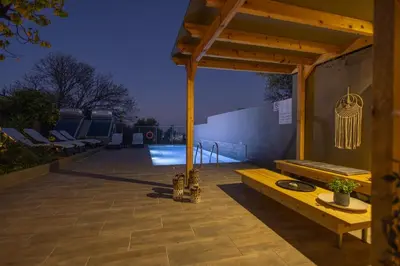 a wooden pergola with a bench on a patio at City Art Villa in Asgourou