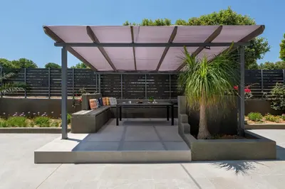 a pergola with a table in a garden at City Art Villa in Asgourou