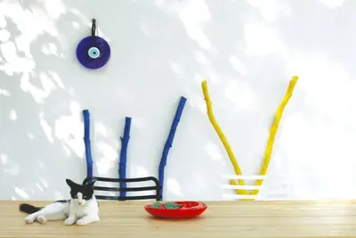 a black and white cat sitting on a table with vases at White dream summer house in Ialyssos