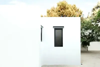 a white building with a black door on it at White dream summer house in Ialyssos