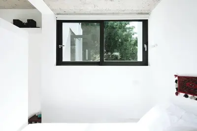 a bedroom with white walls and a window at White dream summer house in Ialyssos