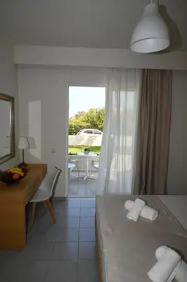 a hotel room with a bed and a desk and a window at Stacy's Studios in Kremasti