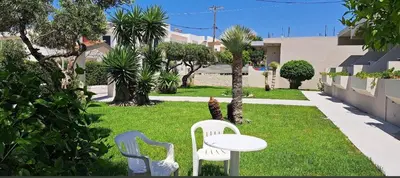 two white chairs and a table in a yard at Stacy's Studios in Kremasti