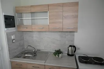 a kitchen with a sink and wooden cabinets at Stacy's Studios in Kremasti