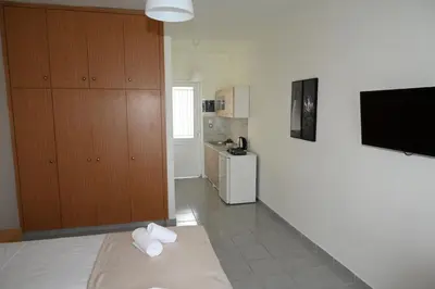a living room with a television and a kitchen at Stacy's Studios in Kremasti