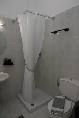 a bathroom with a toilet and a shower curtain at Stacy's Studios in Kremasti