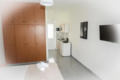 a living room with a television and a kitchen at Stacy's Studios in Kremasti