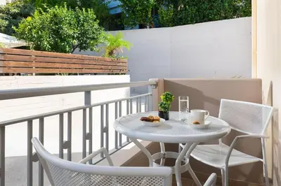 a white table and chairs on a balcony at gefiraki apartment in Koskinou