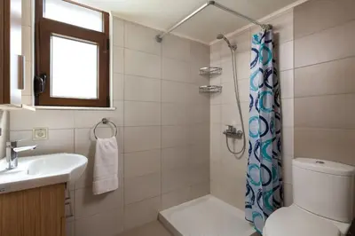 a bathroom with a toilet and a sink and a shower at gefiraki apartment in Koskinou