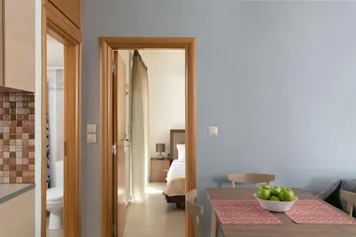 a room with a table with a bowl of fruit on it at gefiraki apartment in Koskinou