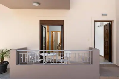 a balcony with a table and chairs on it at gefiraki apartment in Koskinou
