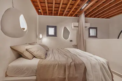 a bedroom with a bed and a wooden ceiling at Noema Lindos - Athena Apartment in Líndos