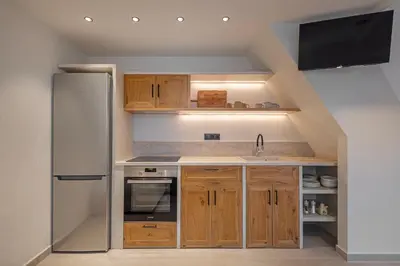 a kitchen with a refrigerator and a sink at Noema Lindos - Athena Apartment in Líndos