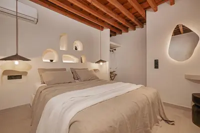 a white bedroom with a large bed in a room at Noema Lindos - Athena Apartment in Líndos