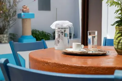 a table with a coffee maker and glasses on it at Genovefa traditional house in Koskinou