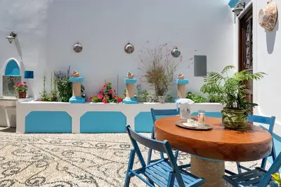 a table and chairs in a room with flowers at Genovefa traditional house in Koskinou