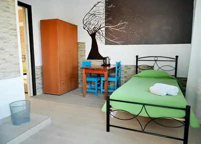 a bedroom with a bed and a desk and a table at Karmik Concept Apartments in Afantou