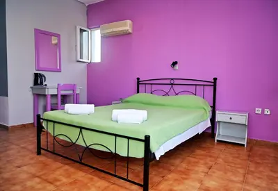 a bedroom with a bed with a purple wall at Karmik Concept Apartments in Afantou