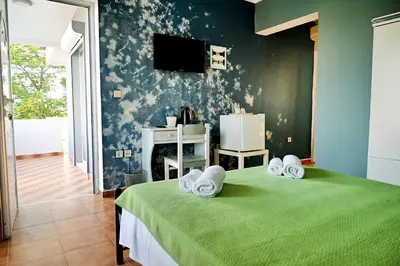 a bedroom with a green bed with towels on it at Karmik Concept Apartments in Afantou