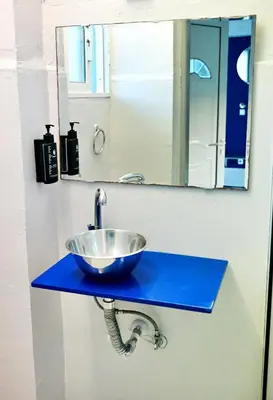 a bathroom sink with a bowl on a blue counter at Karmik Concept Apartments in Afantou