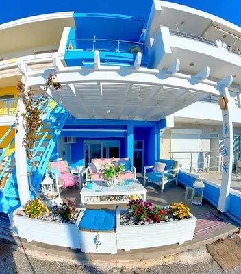 a balcony on a yacht with blue walls and flowers at Beach Studio - Sleeps 2 & Private Ocean Terrace in Haraki