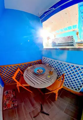 a table and chairs in a room with a blue wall at Beach Studio - Sleeps 2 & Private Ocean Terrace in Haraki