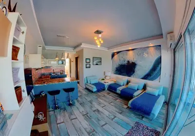 a living room with a blue couch and a table at Deluxe Beach Apartment- Sleeps 2 & Private Terrace in Haraki