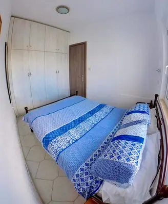a bedroom with a bed with blue and white sheets at Deluxe Beach Apartment- Sleeps 2 & Private Terrace in Haraki