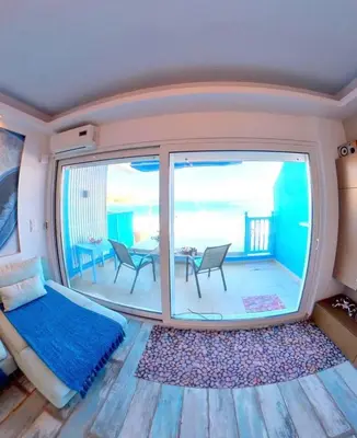 a bedroom with a bed and a large window at Deluxe Beach Apartment- Sleeps 2 & Private Terrace in Haraki