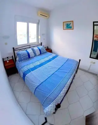 a bedroom with a large bed with a blue comforter at Deluxe Beach Apartment- Sleeps 2 & Private Terrace in Haraki