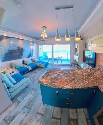 a kitchen and living room with a blue island at Deluxe Beach Apartment- Sleeps 2 & Private Terrace in Haraki