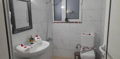 a white bathroom with a toilet and a sink at A&J Apartments in Gennadi