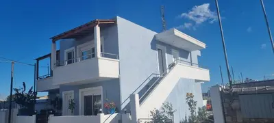 a white building with a balcony on top of it at A&J Apartments in Gennadi