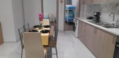 a kitchen with a table with chairs and a sink at A&J Apartments in Gennadi