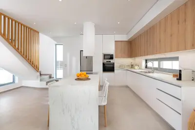 a kitchen with white cabinets and a counter with oranges on it at Martini Villas in Kremasti