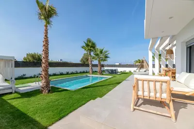 a backyard with a swimming pool and palm trees at Martini Villas in Kremasti