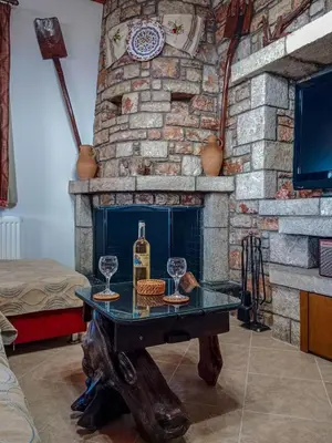 a table with a bottle of wine and two glasses at Tsampika's Traditional Stone Cottage in Siana in Siána