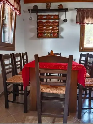 a dining room with a red table and chairs at Tsampika's Traditional Stone Cottage in Siana in Siána